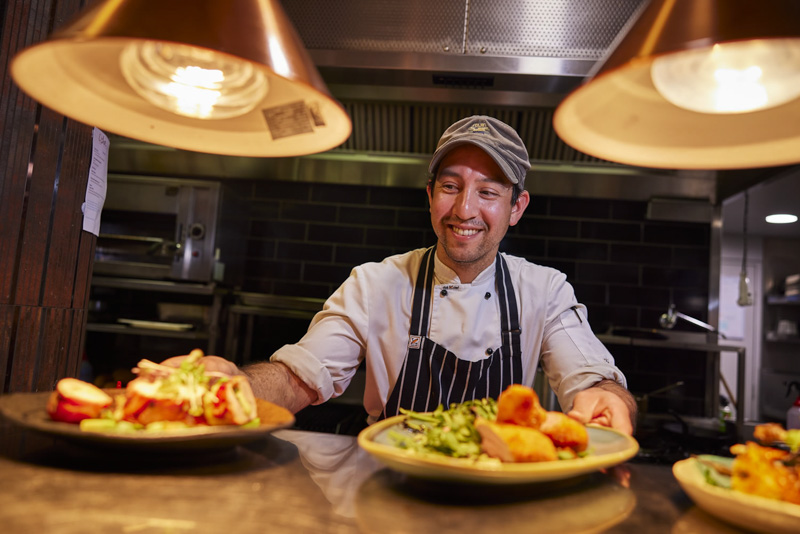 A chef presents the meal at Ochre restaurant